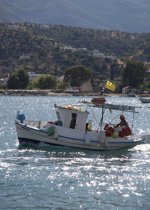 A fishing boat leaves Poros harbour, home of the Greek Sails flotilla & bareboat sailing fleet