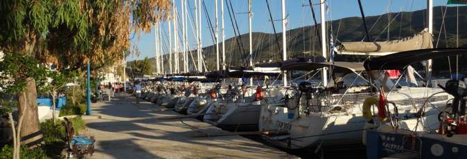 Greek Sails yachts sit in the sun on the Poros quayside awaiting their next flotilla holiday and bareboat yacht charter sailing holiday crews