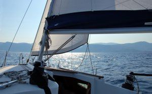 The afternoon sun glistens behind the genoa of a Greek Sails Sun Odyssey 29.2 yacht