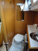 The main cabin toilet/wc (heads) of the Jeanneau Sun Odyssey 409 sailing yacht, with the separate shower compartment behind you and separated from the toilet by a folding screen