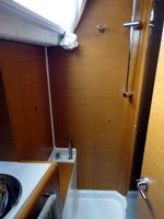 The main cabin shower of the Jeanneau Sun Odyssey 409 sailing yacht, with toilet behind you and separated from the shower by a folding screen