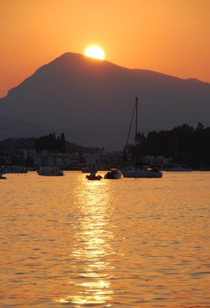 The sun sets behind the knees of the Lady of Poros, Peloponnese, Greece